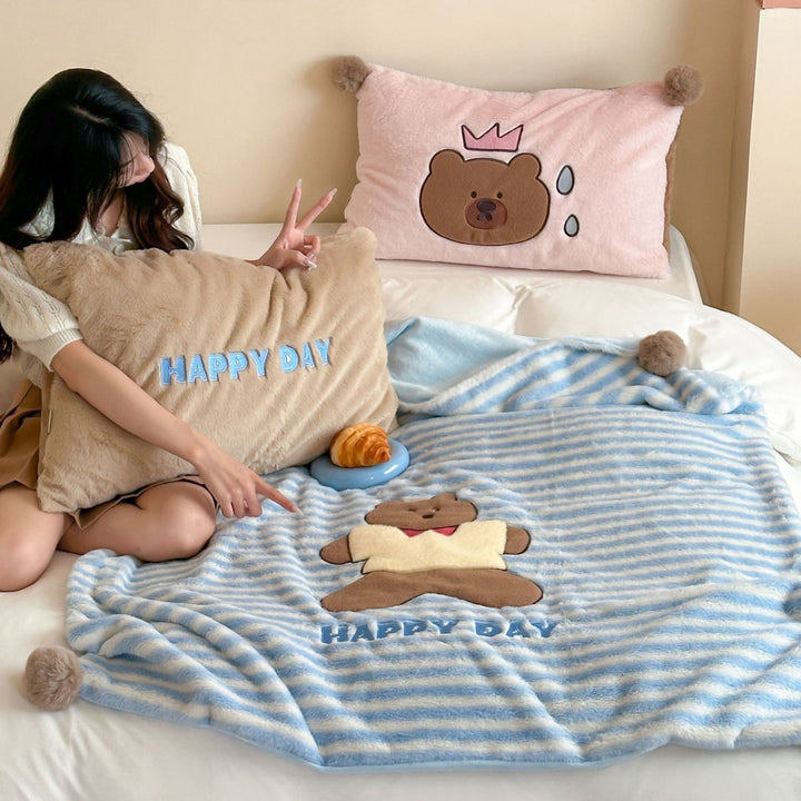 Plush cuddle blanket with striped texture, pom-pom corners & embroidered bear motif