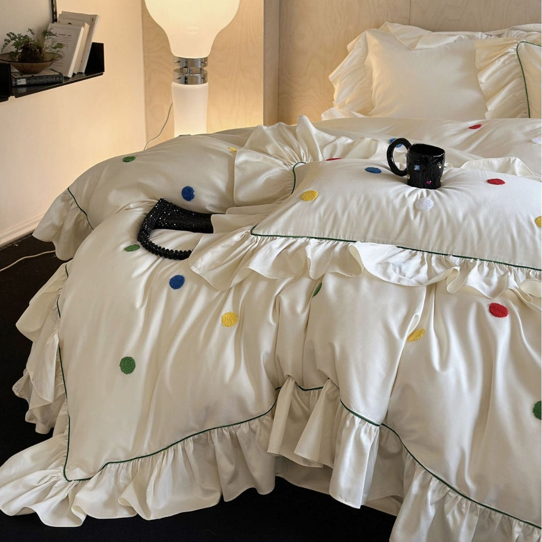 Playful bedding set with frill, colorful flock applications, and fine piping