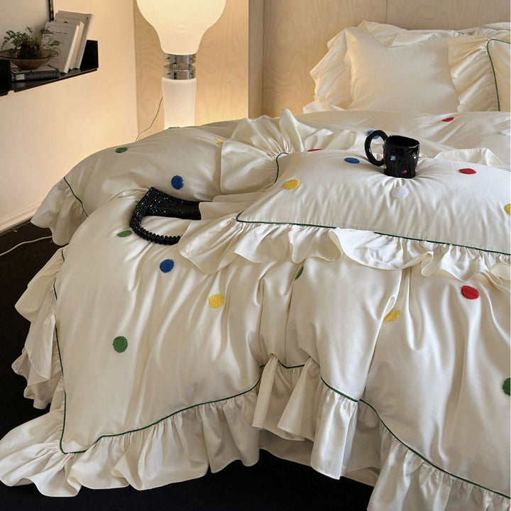 Playful bedding set with frill, colorful flock applications, and fine piping