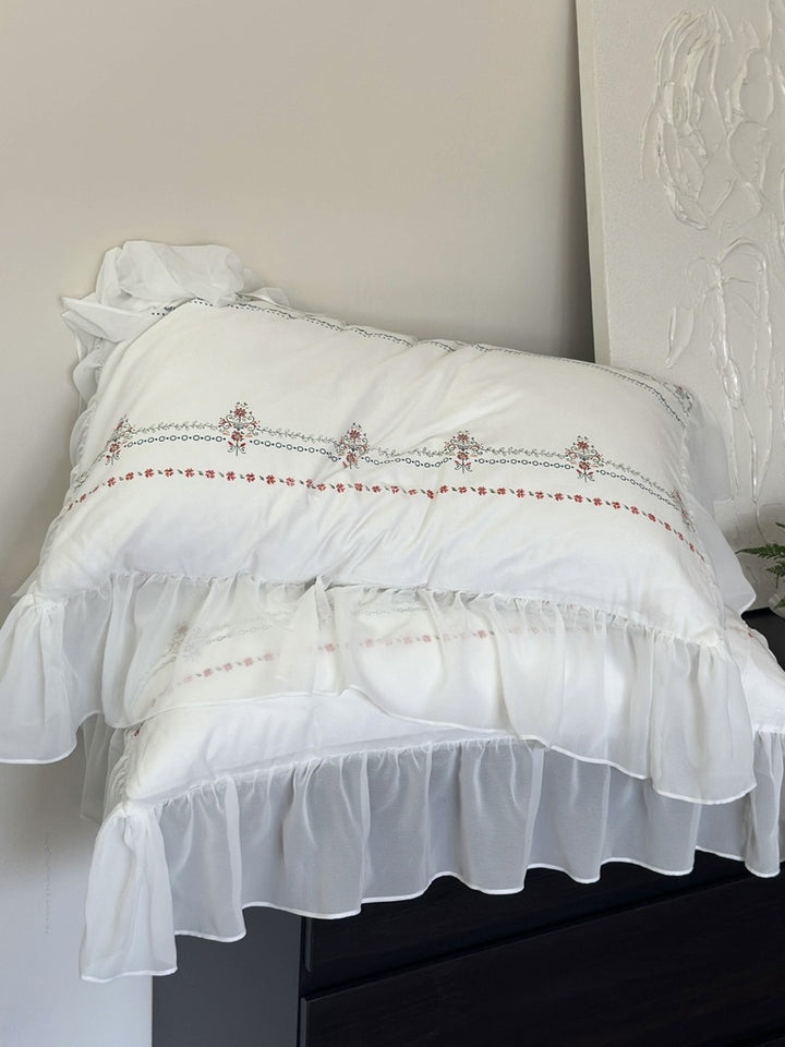 Lightly washed cotton bedding set with ruffled border and fine floral embroidery