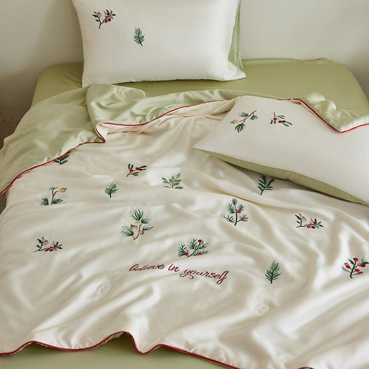 Luxurious satin bed linen set with embroidered Christmas tree motifs and contrasting piping