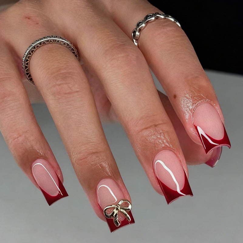 Artificial nail set with elegant red tips and refined bow decorations Stornfield