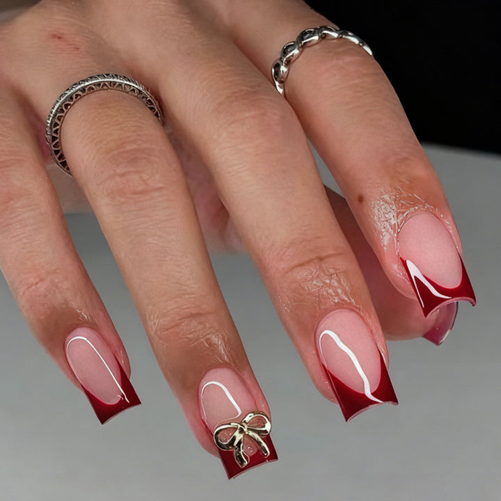 Artificial nail set with elegant red tips and refined bow decorations Stornfield