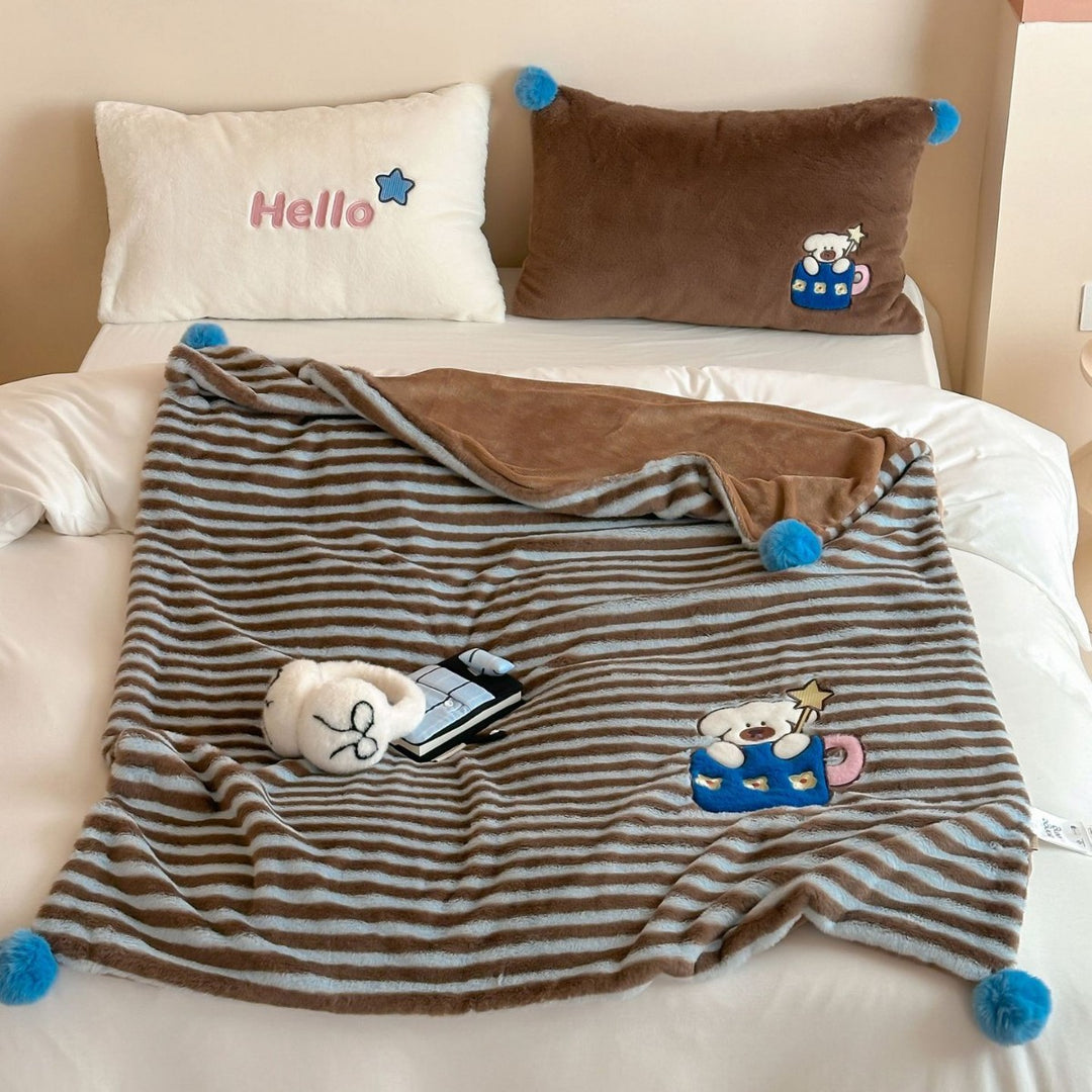 Plush cuddle blanket with striped texture, pom-pom corners & embroidered bear motif
