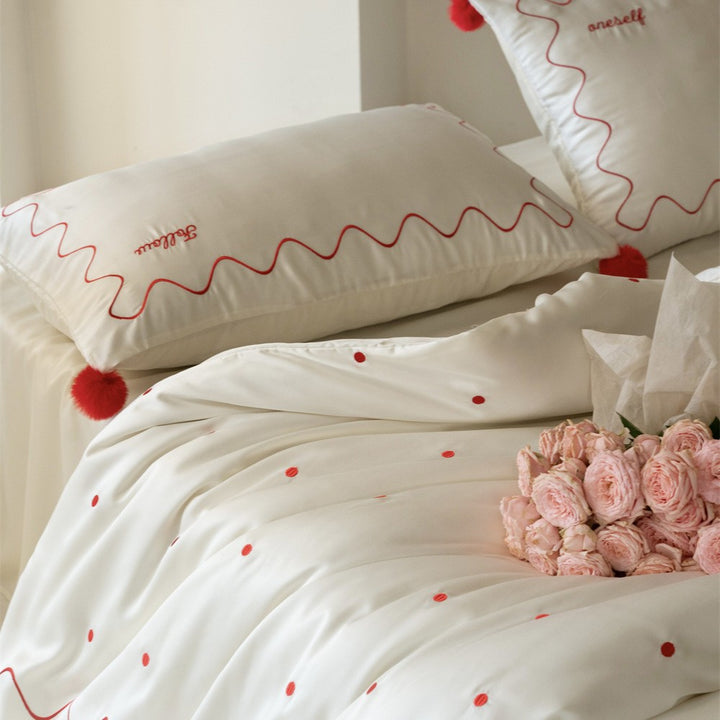 Bedding set made of cotton satin with wavy embroidery edge and pompom cushion