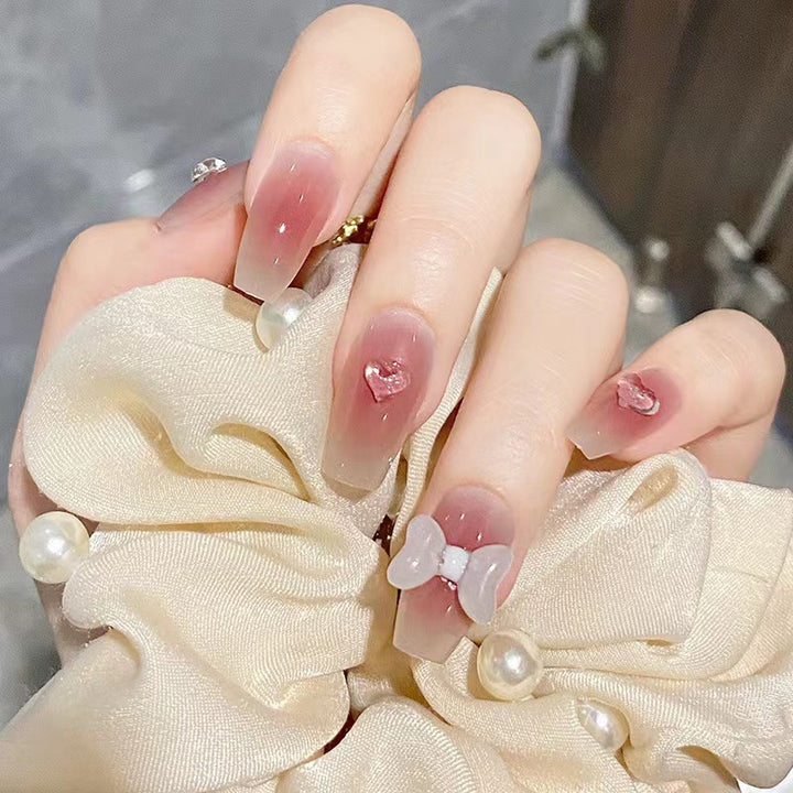 Artful acrylic nails with heart and bow design Stornfield