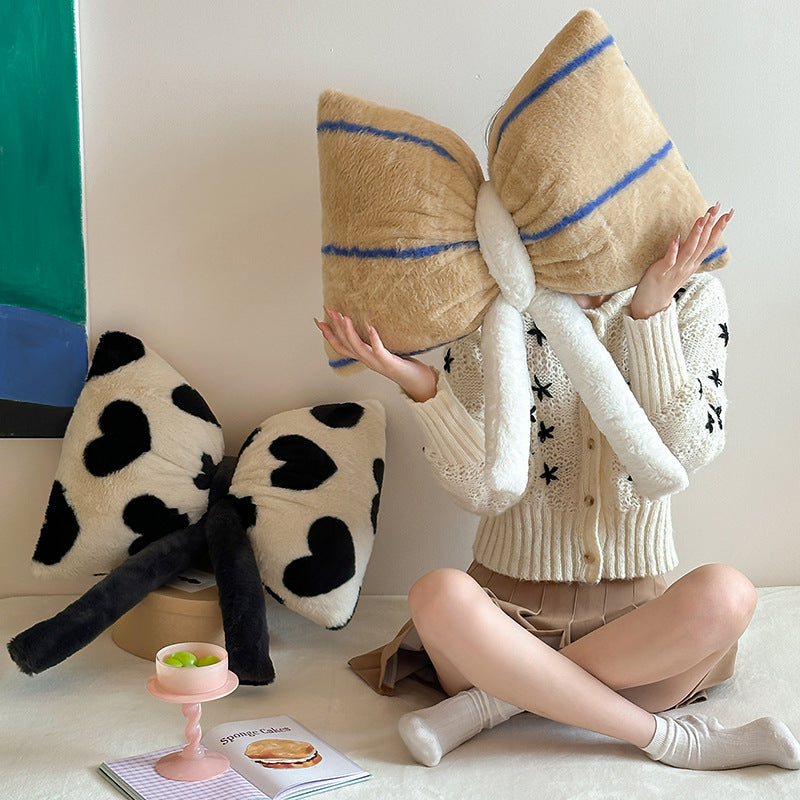 Cuddle cushion in bow shape made of plush with striped texture