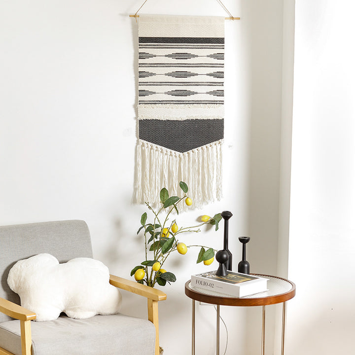 Woven wall hanging in Aztec style with cotton fringes and wooden rod