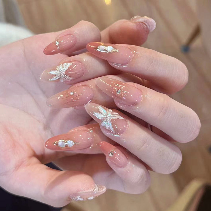 Artificial nail extensions with floral motifs and glitter accents Stornfield