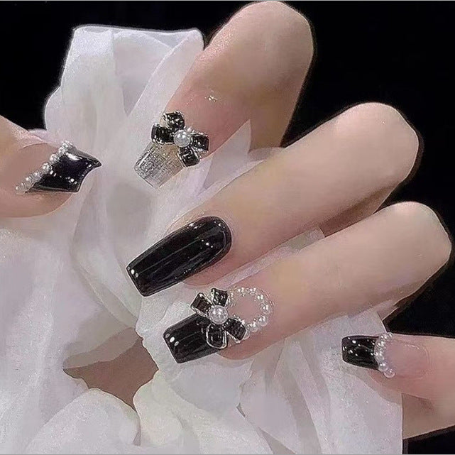 Artistic Nail Art with Glitter and Flower Applications Stornfield