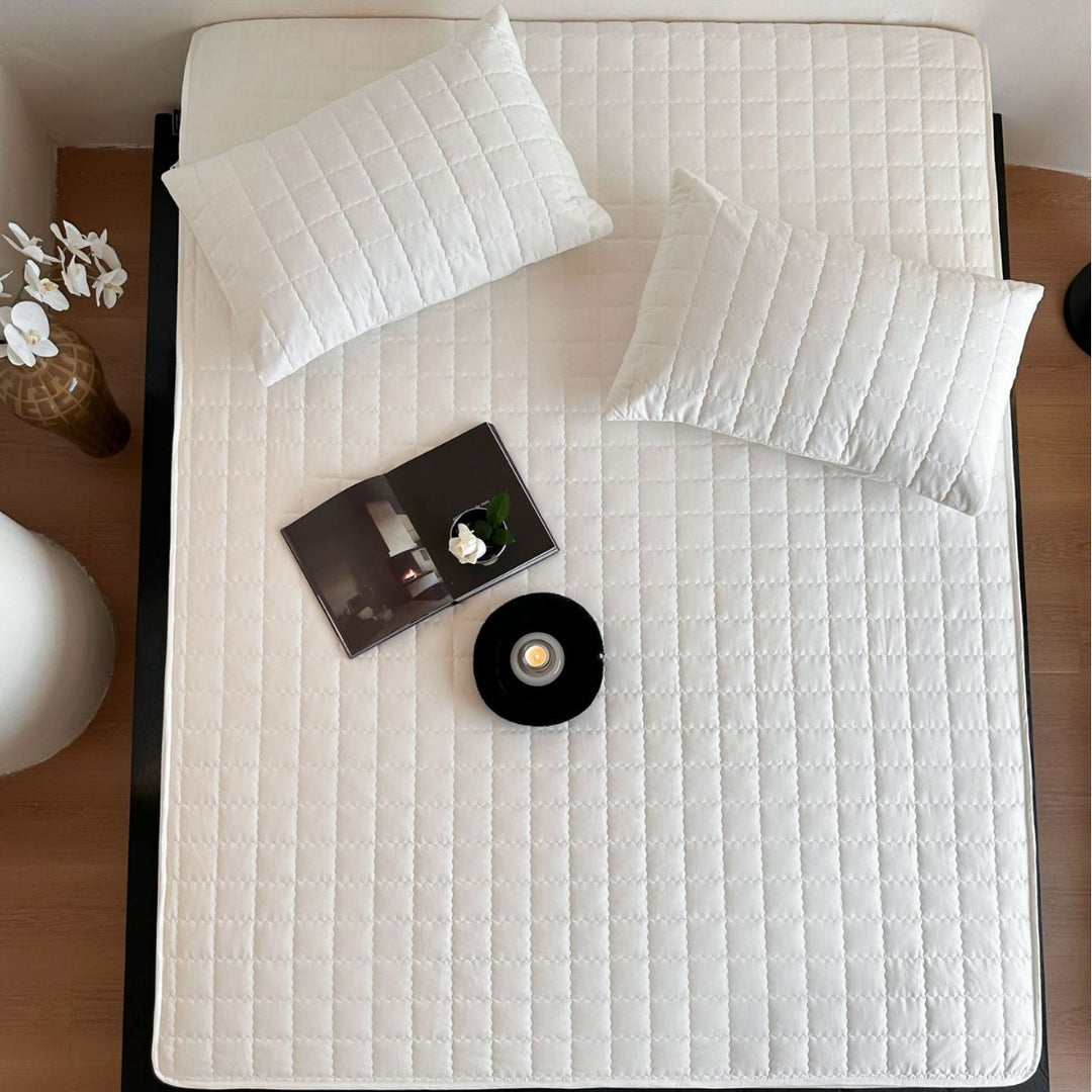 Padded quilted mattress topper with non-slip bottom and breathable fiber filling