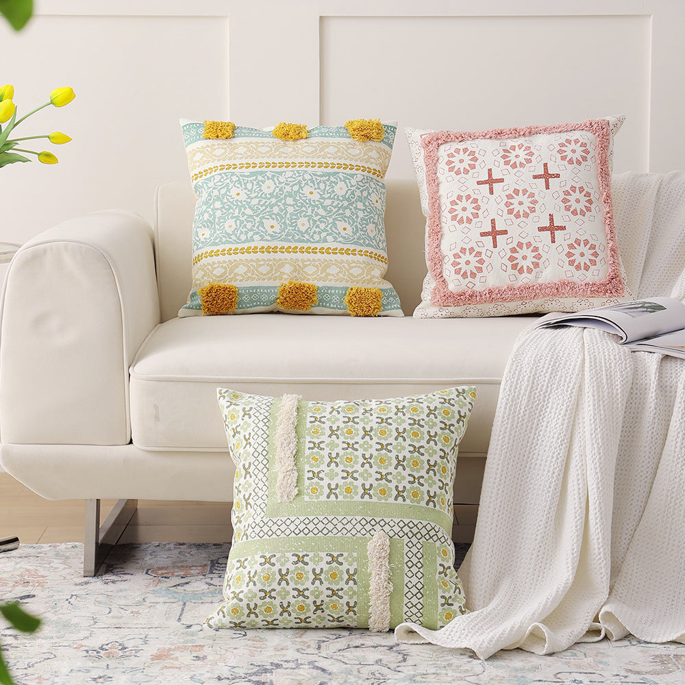 Woven decorative pillow with botanical jacquard pattern and pom-pom trim
