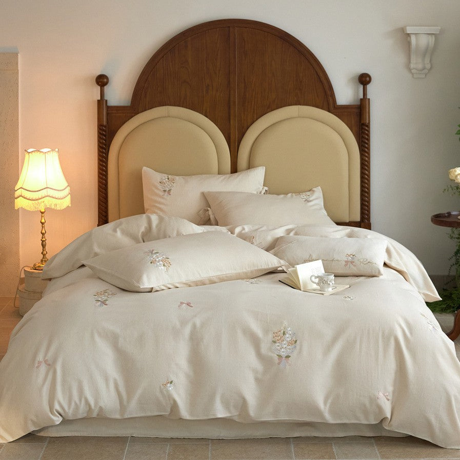 Romantic cotton satin duvet cover set with delicate floral embroidery and decorative pillow
