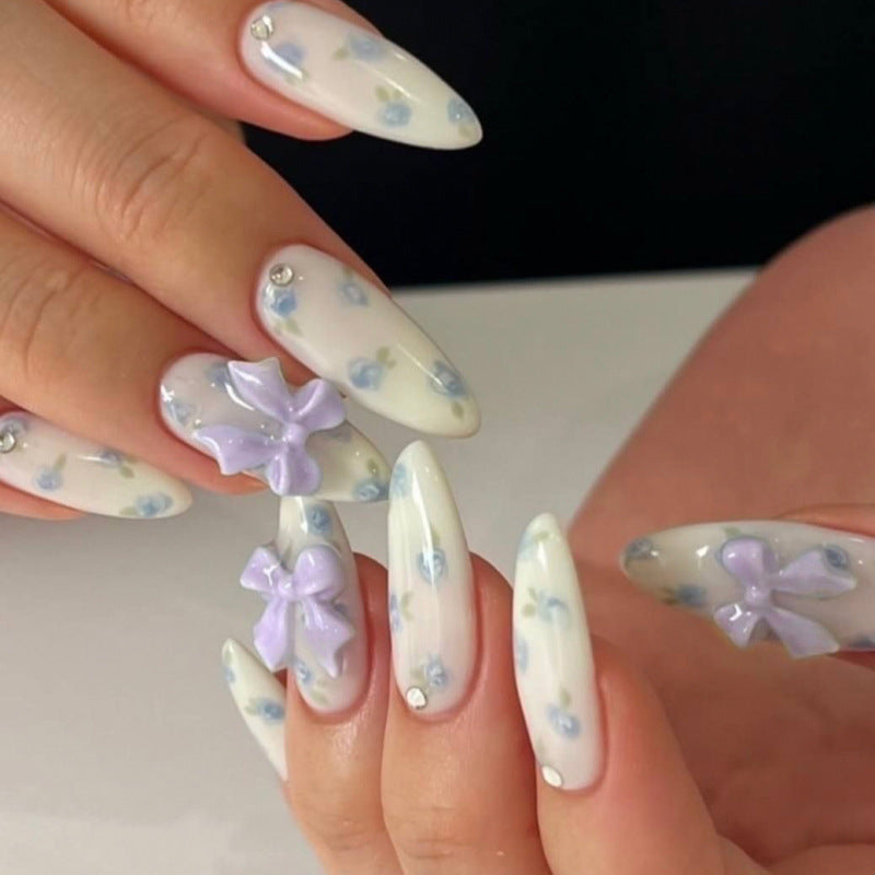 Artful stiletto nails with delicate flower patterns and glitter accents Stornfield