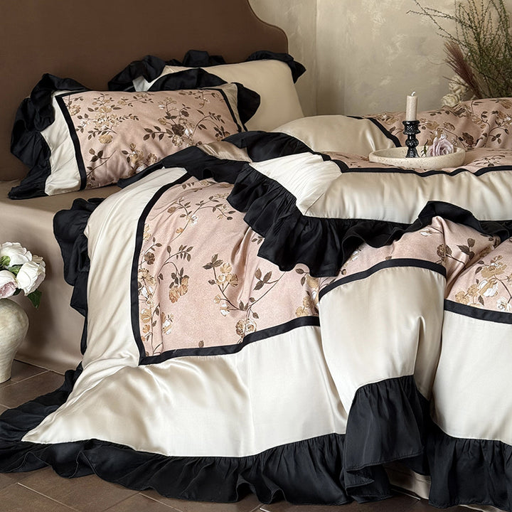 Satin bedding set with embroidered flower appliqués, layered flounce and decorative cushion