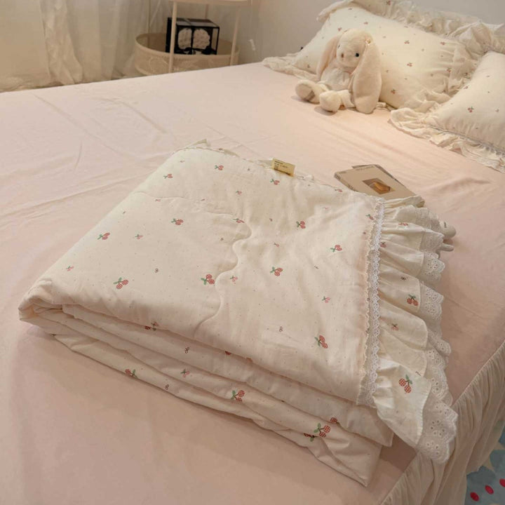 Quilted bedspread with ruffle and lace trim made of cotton blend