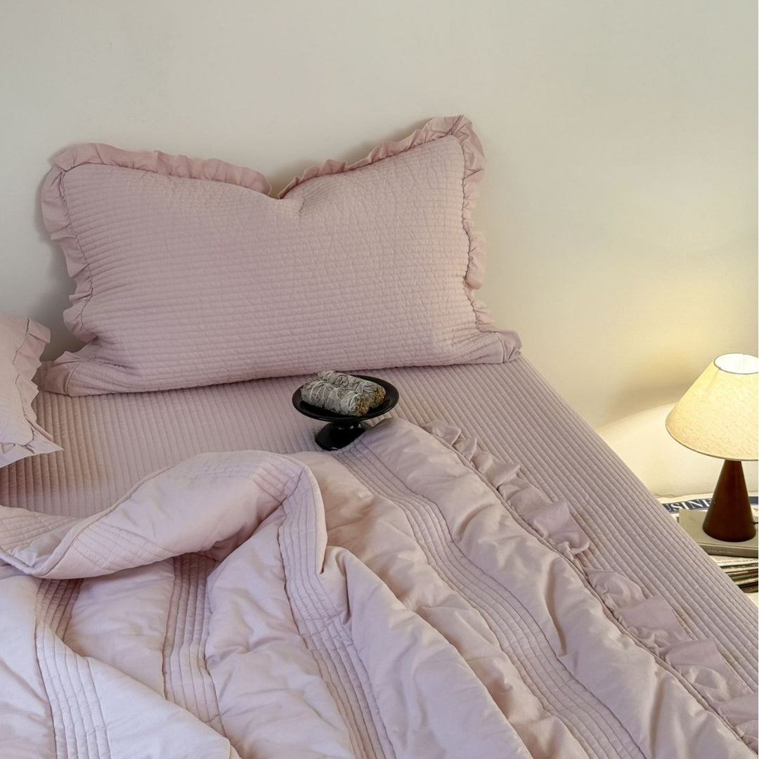 Padded quilted bedding set with ruffled trim and fine channel stitching