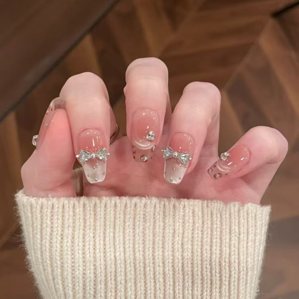 Art nails with delicate rhinestone and bow accents Stornfield