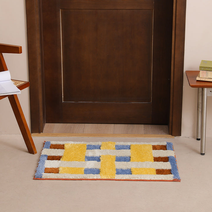 Rectangular tufted door mat with geometric block pattern and non-slip backing Stornfield
