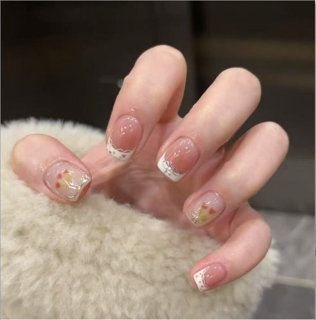 Artistic Nail Art with Glitter and Flower Applications Stornfield