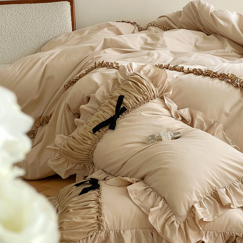 Luxurious satin bedding set with gathered ruffle, braided decorative ribbons and bow appliqué