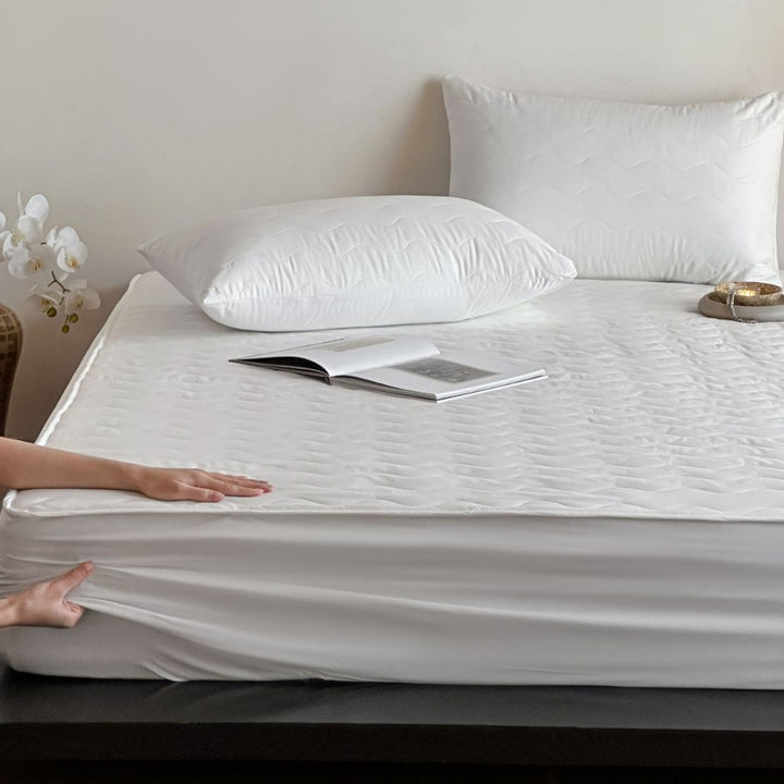 Padded mattress protector with all-round stretch and quilting