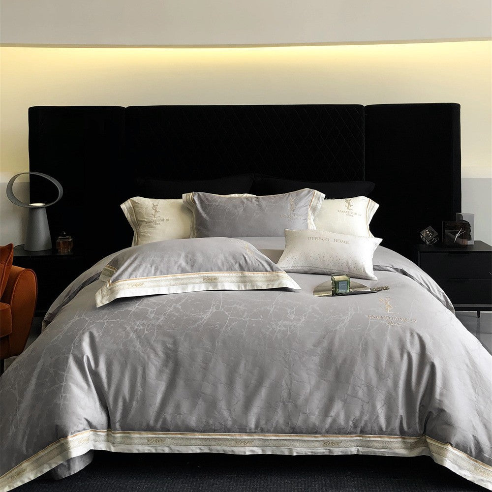 Luxurious satin bedding set with subtle marble texture and golden embroidered border