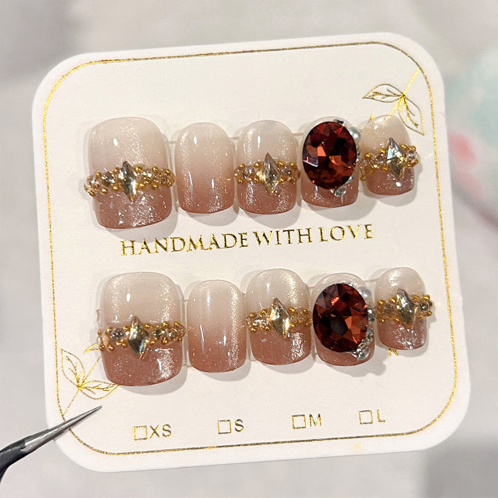 Artificial nail art with glitter and jewelry embellishments Stornfield