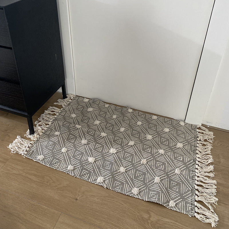 Hand-tufted bathroom mat with fringes, decorative dot-and-dash pattern and non-slip backing Stornfield