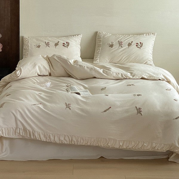 Cotton bedding set with delicate floral embroidery and ruffled edge