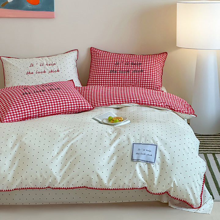 Striped cotton bedding set with subtle slogan appliqués and decorative piping