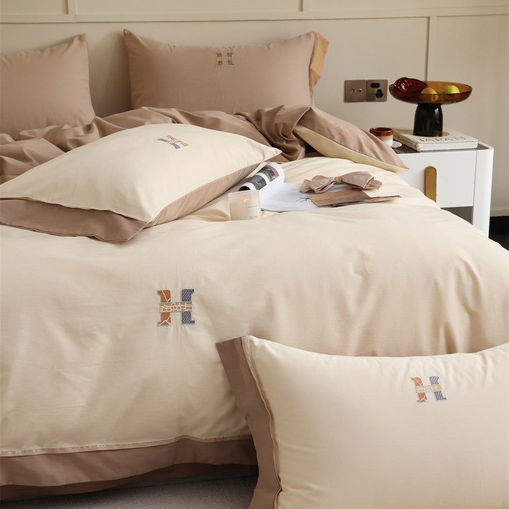 Luxurious cotton satin bedding set with contrasting piped edge and monogram embroidery