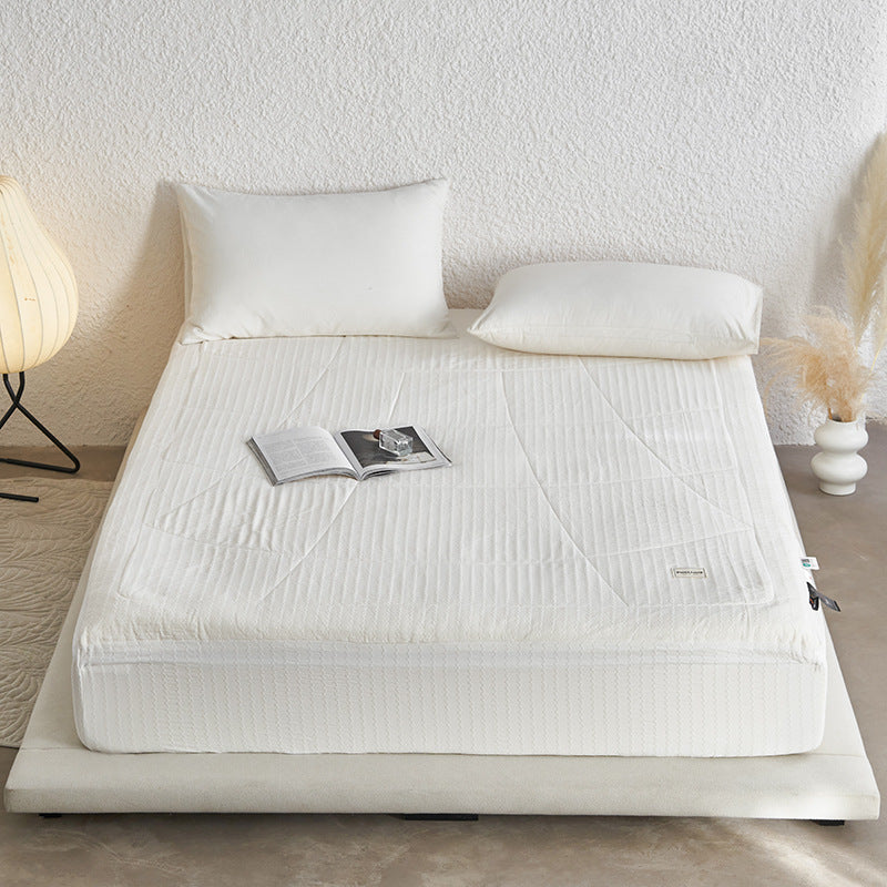 Padded mattress topper with quilted microfiber surface and non-slip fitted edge