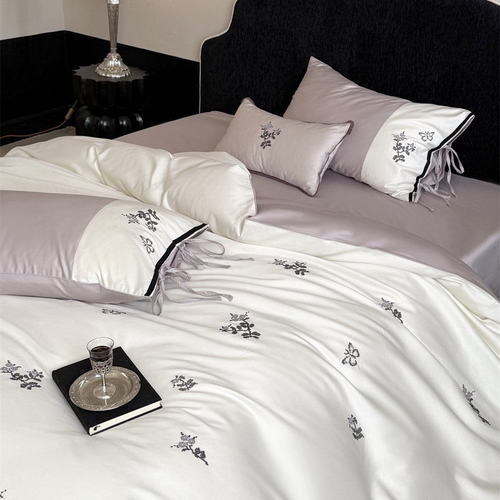 Luxurious satin bedding set with embroidered flower pattern and decorative pillow