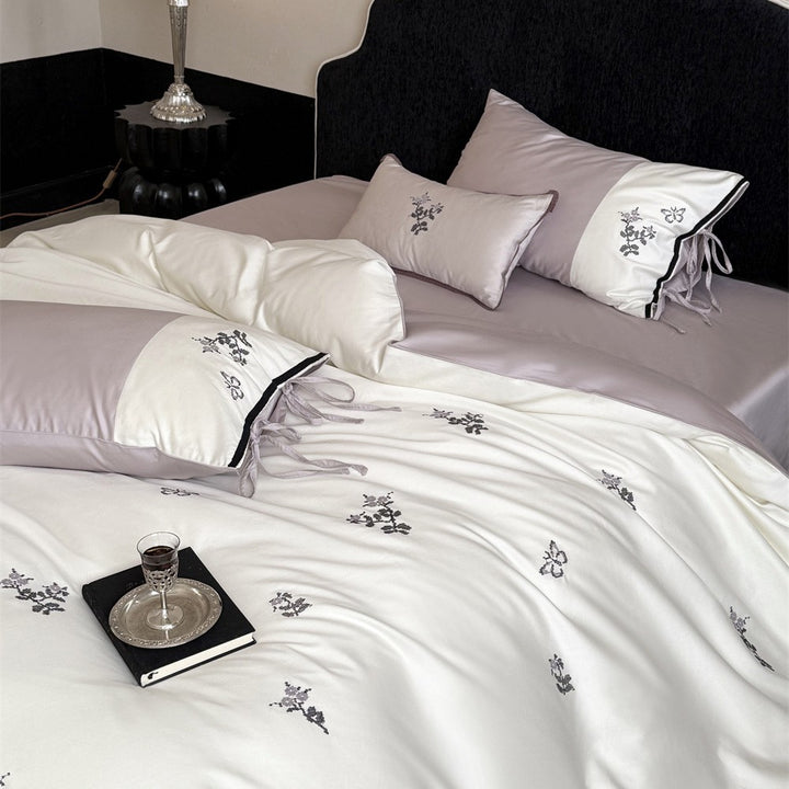 Luxurious satin bedding set with embroidered flower pattern and decorative pillow
