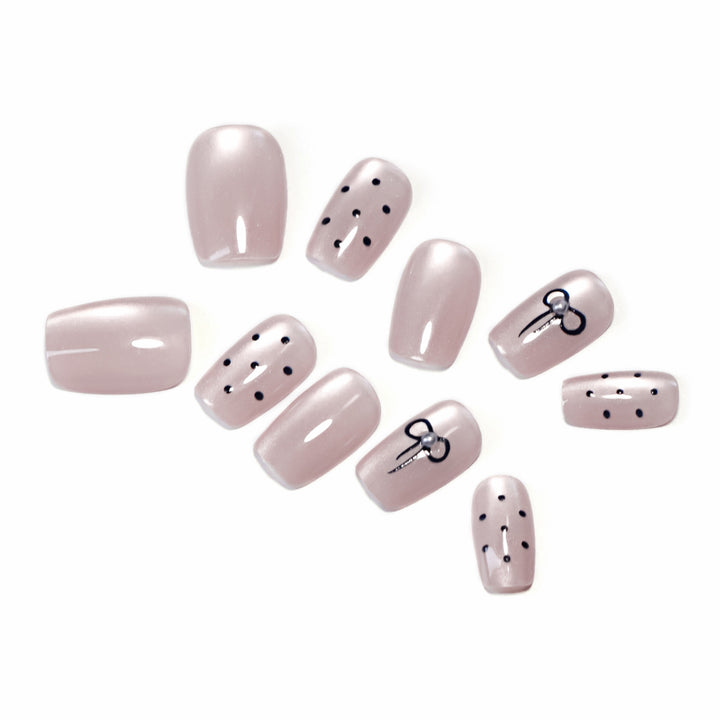 Artificial nail extensions with decorative bows and dots Stornfield