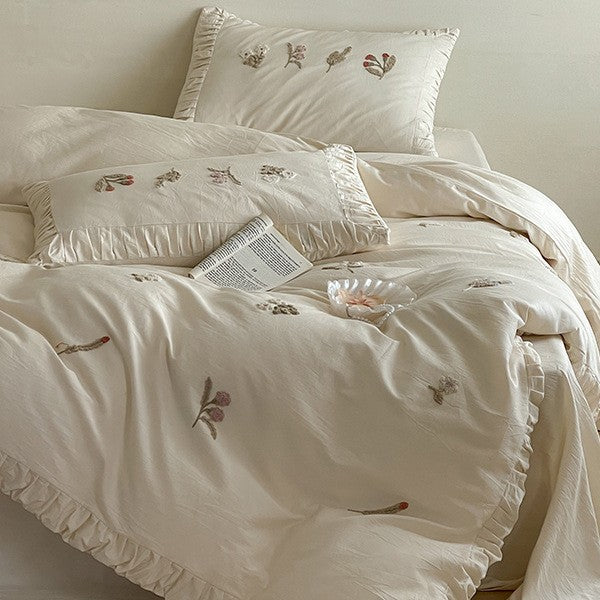 Cotton bedding set with delicate floral embroidery and ruffled edge