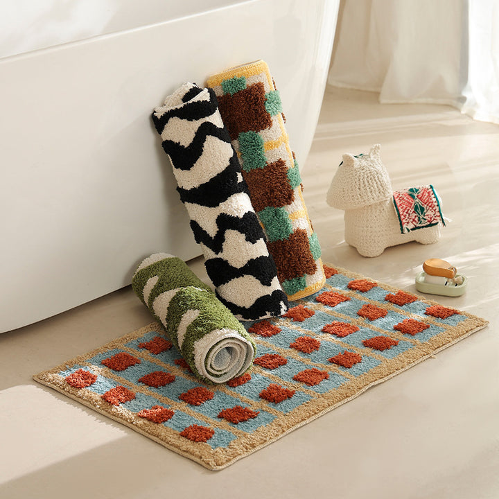 Hand-tufted bathroom bath mat with non-slip backing and textured square relief Stornfield