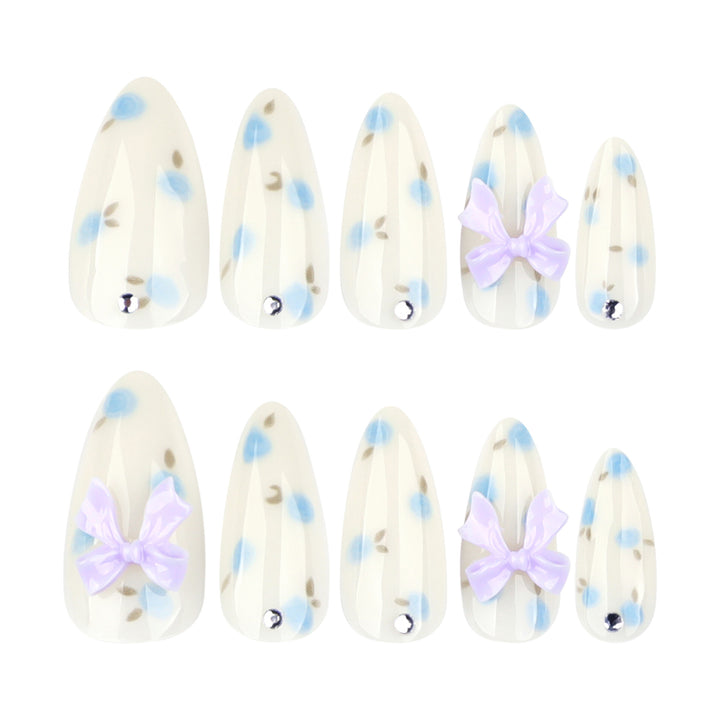 Artful stiletto nails with delicate flower patterns and glitter accents Stornfield