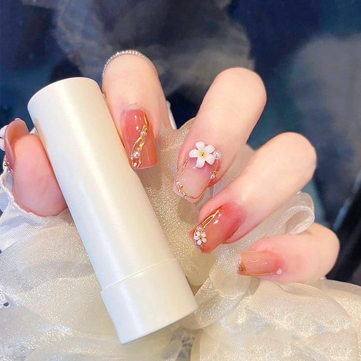 Acrylic nail set with elegant floral decorations and glamorous pearl accents Stornfield
