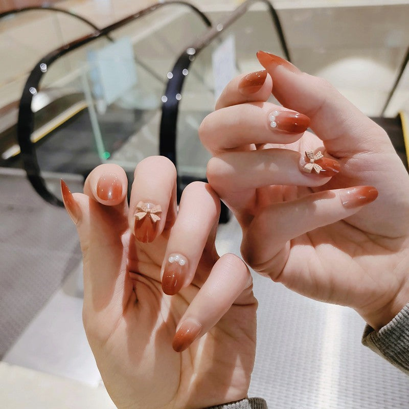 Artificial nails with elegant bow accents and pearl decorations Stornfield