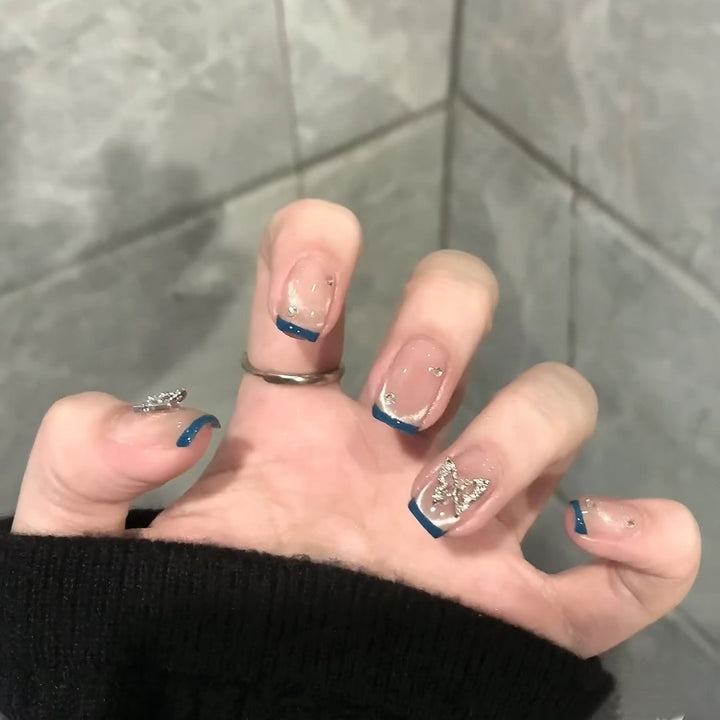 Artificial nails with trendy French tips and decorative glitter accents Stornfield