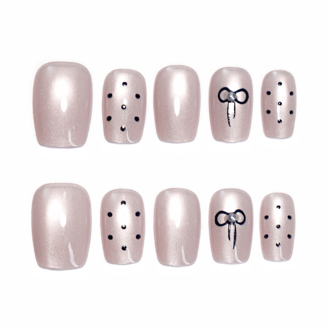 Artificial nail extensions with decorative bows and dots Stornfield