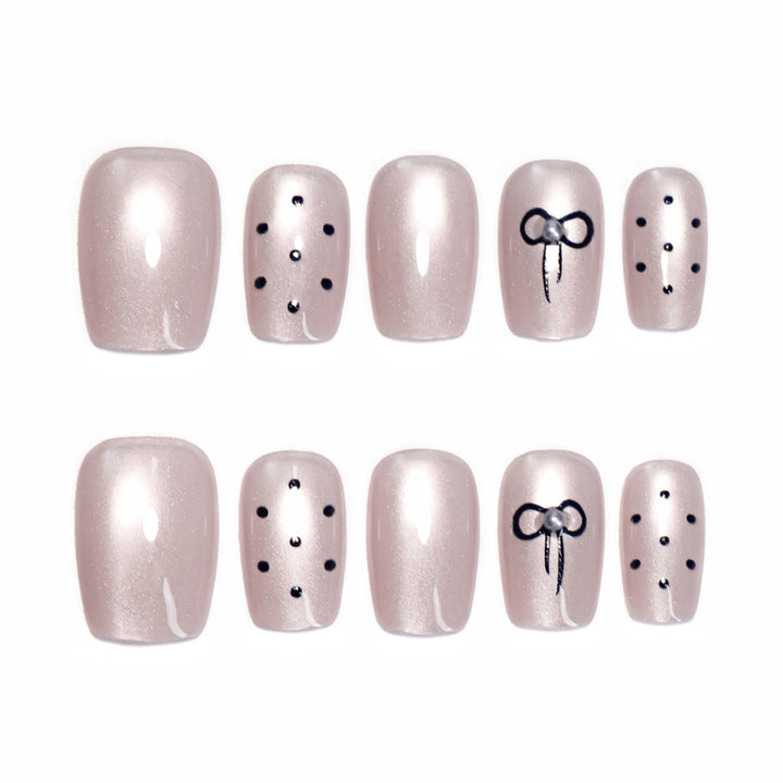 Artificial nail extensions with decorative bows and dots Stornfield