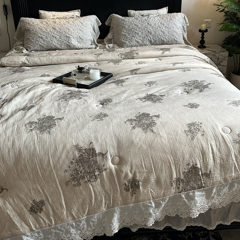 Quilted bedspread with lace trim and vintage stripe pattern