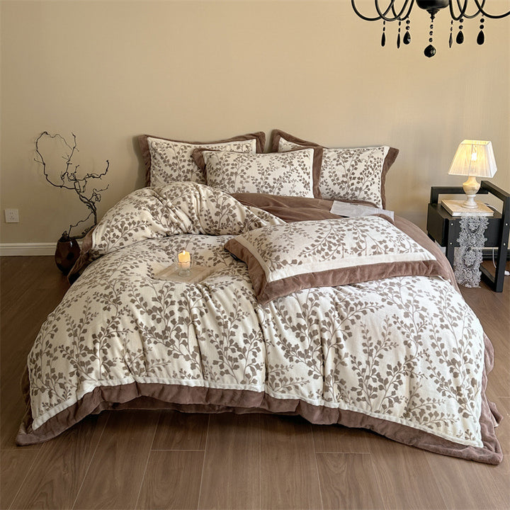 Luxurious quilted bedding set with velvet trim and floral branch motif