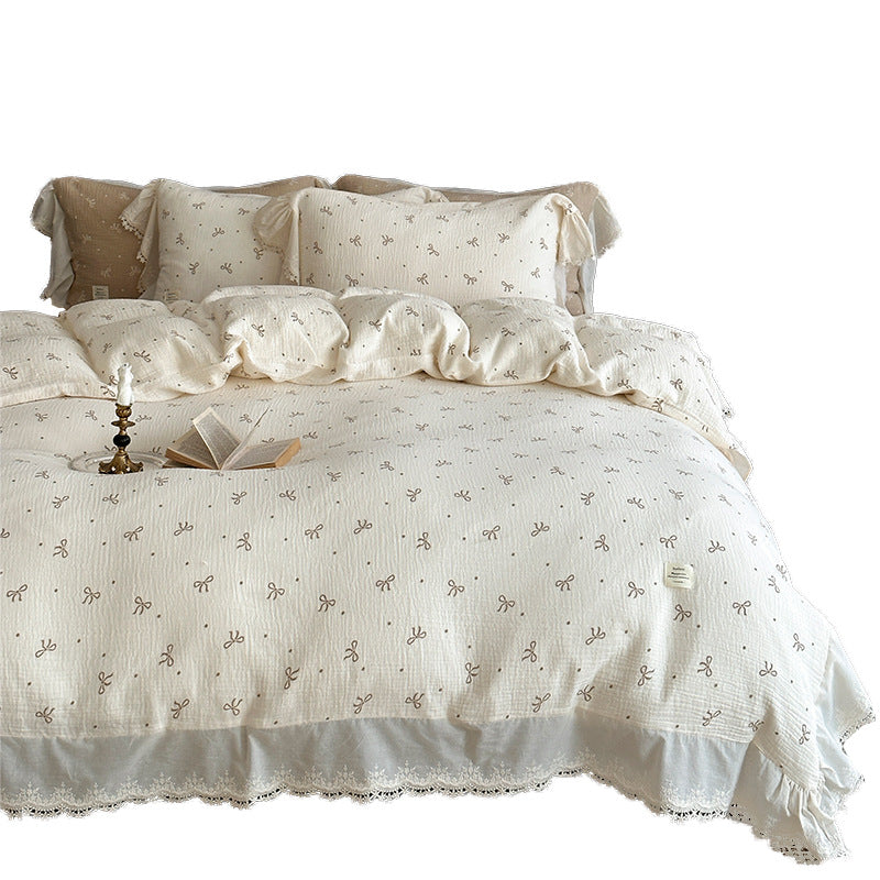 Cotton muslin bedding set with ruffles, lace trim, and delicate bow print