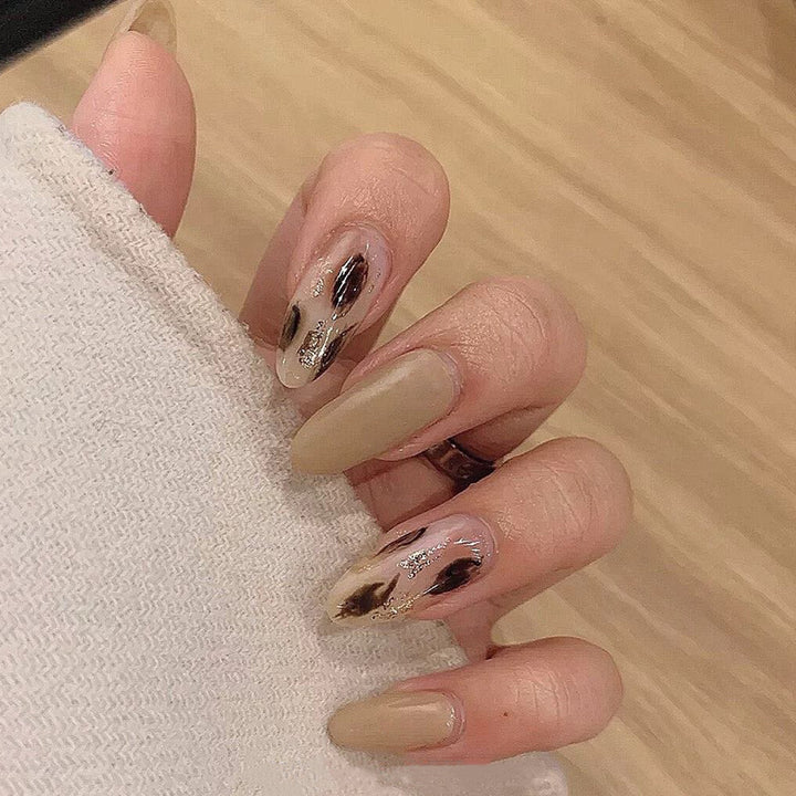 Artificial nail extensions with modern design and glitter accents Stornfield