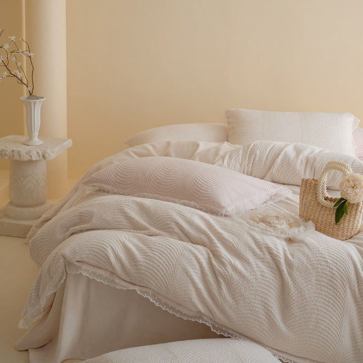 Quilted bedding set with lace edge and wave quilting pattern