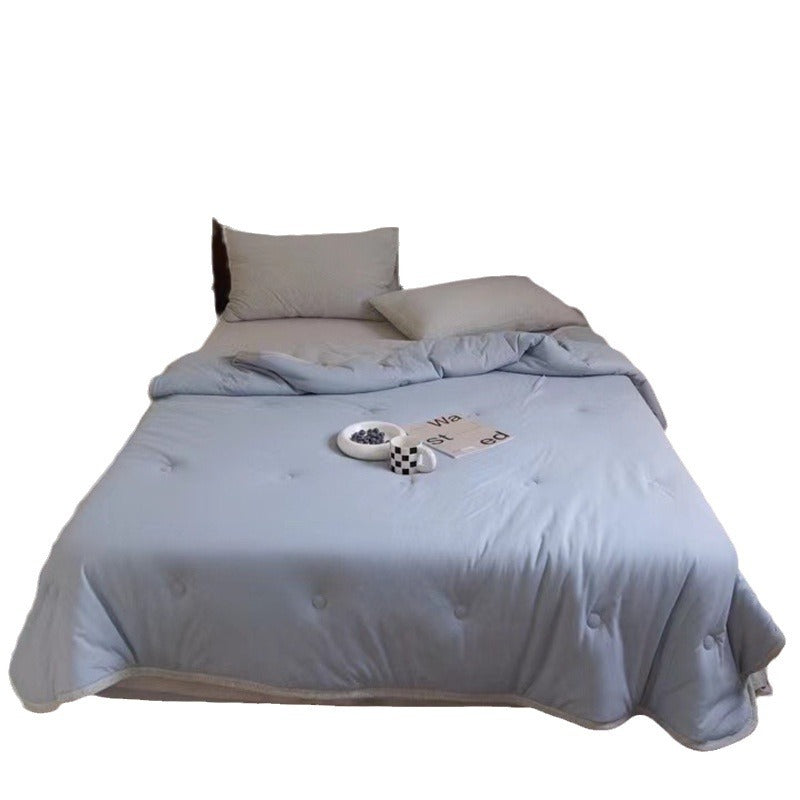 Light reversible quilted blanket made of microfiber with soft decorative stitching